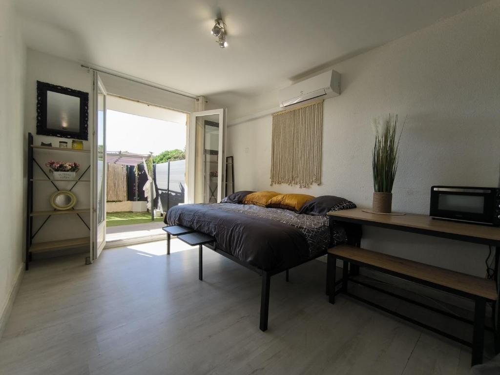 une chambre avec un lit et une porte coulissante en verre dans l'établissement Studio rénové avec jardin proche de la plage, à Canet