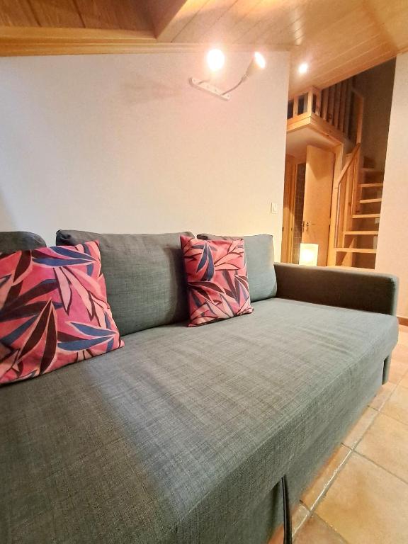 a couch with two pillows on it in a room at PROBER-CHAMOIX 68 in Encamp