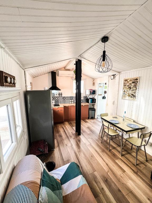 un salon avec une table et une cuisine dans l'établissement Maisonnette de pêcheur chauffée et climatisée, à Port-la-Nouvelle