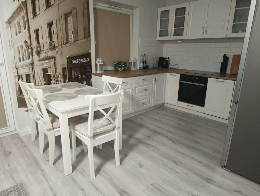 a kitchen with a white table and white chairs at Apartament pod Złotym Bocianem in Świdnica