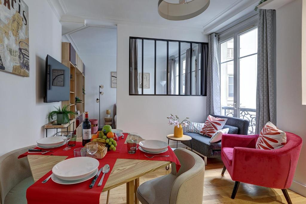 un salon avec une table et un tissu de table rouge dans l'établissement Élégante Suite Haussmannienne au Prestige Parisien, à Paris