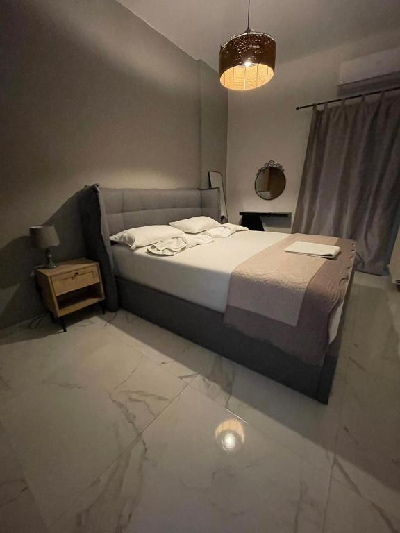 a bedroom with a bed and a table and a lamp at Anais apartment in Preveza