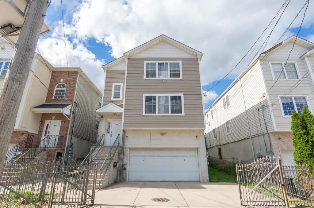 a house with a garage in a neighborhood at 4 Bedroom-Airport Convient in University of Medicine and Dentistry Rooftop Heliport
