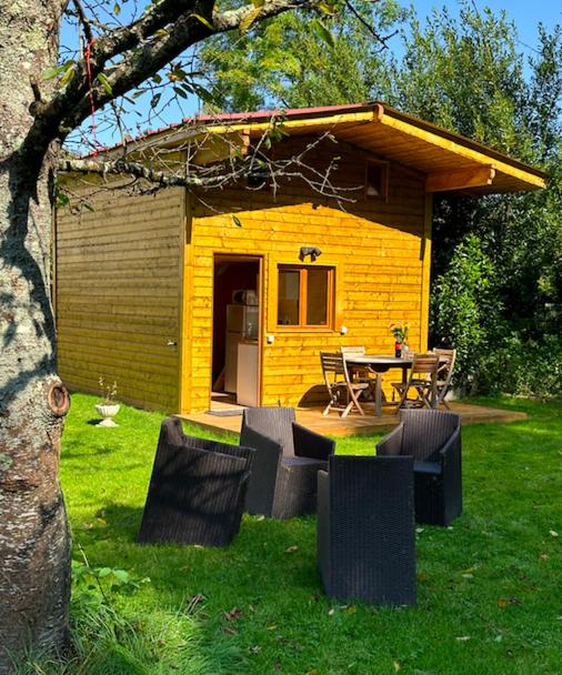 a small yellow house with a table and chairs at Chalet Disney 25min linge compris in La Celle-sur-Morin