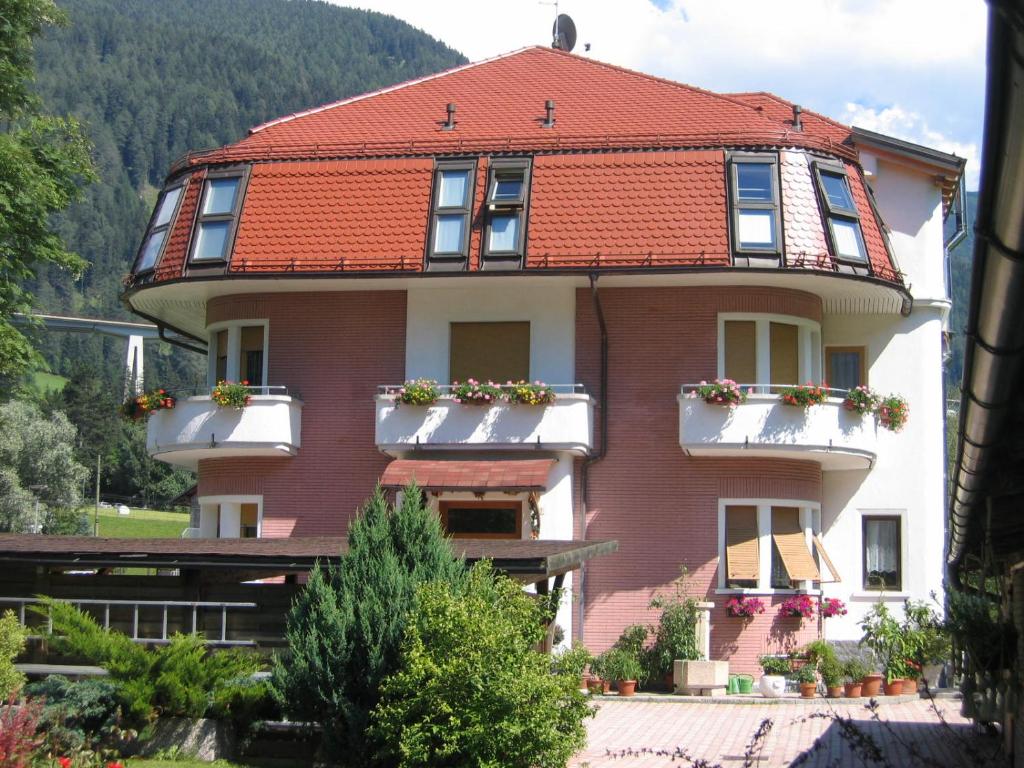 ein großes Haus mit rotem Dach in der Unterkunft Villa Alessandra in Gossensaß