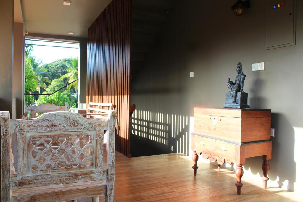 a room with a bed and a dresser with a statue on it at The Chariot Hikkduwa Resort in Hikkaduwa