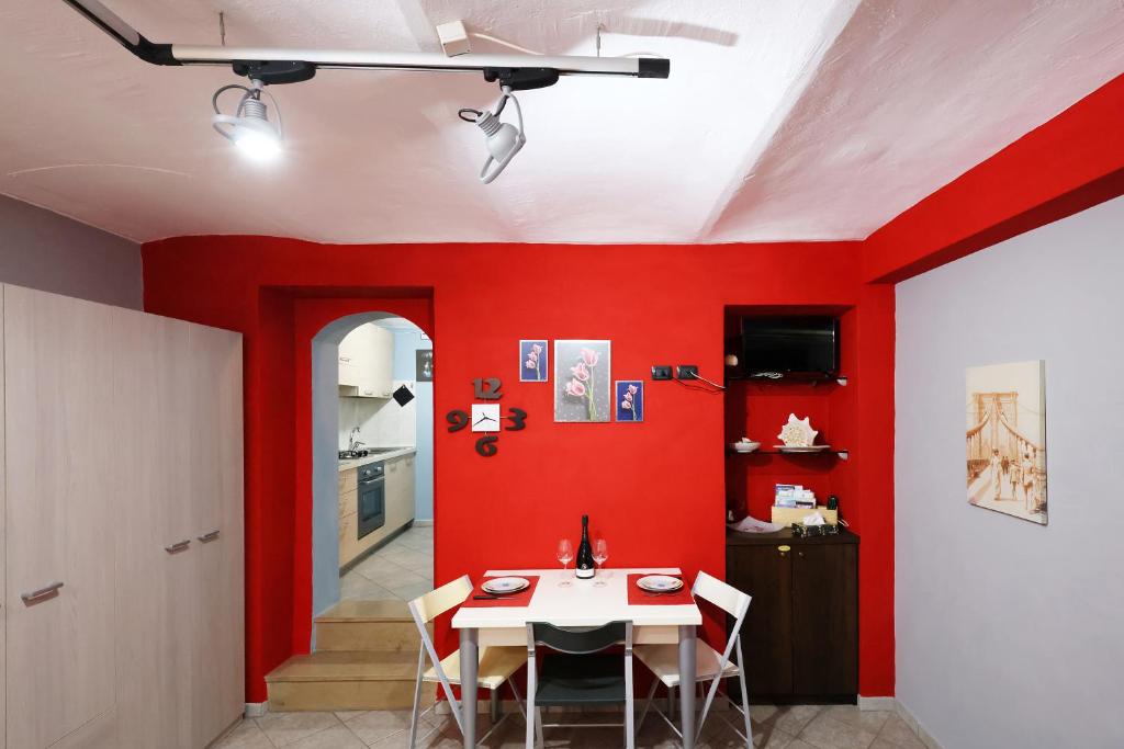 a dining room with red walls and a table at Casa vacanze Re Cit Diano d'Alba in Diano dʼAlba