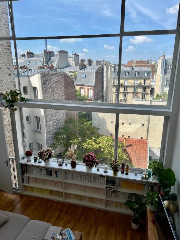 d'une grande fenêtre avec vue sur la ville. dans l'établissement Un duplex de charme à Paris, à Paris