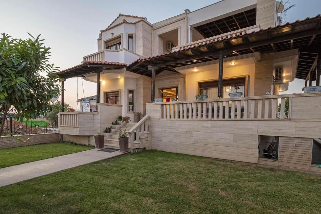 ein großes Haus mit Balkon und Garten in der Unterkunft Villa Anastazia in Paralia Dionisiou