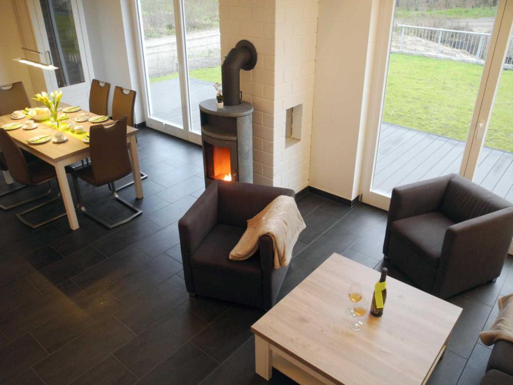 a living room with a fireplace and a table and chairs at Vechteperle - Nordhorn in Nordhorn