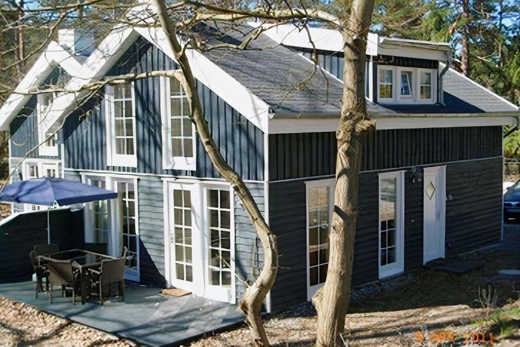 a black and white house with a table and an umbrella at Feenwald - Baabe in Baabe