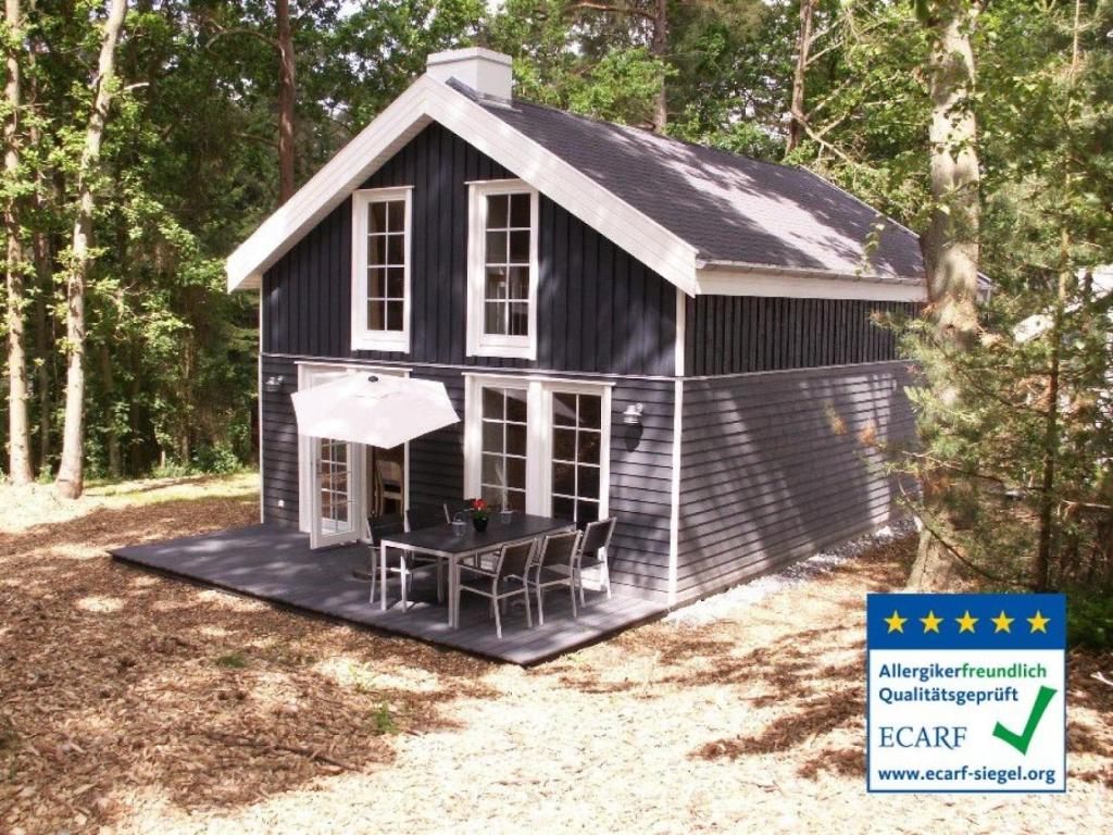 una casa nera con un tavolo davanti di Seebrise Baabe a Baabe