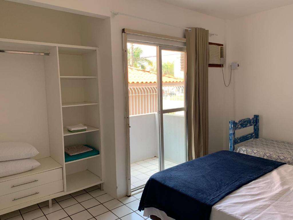 een slaapkamer met een bed en een deur naar een balkon bij Sol-datelli Apês Floripa in Florianópolis