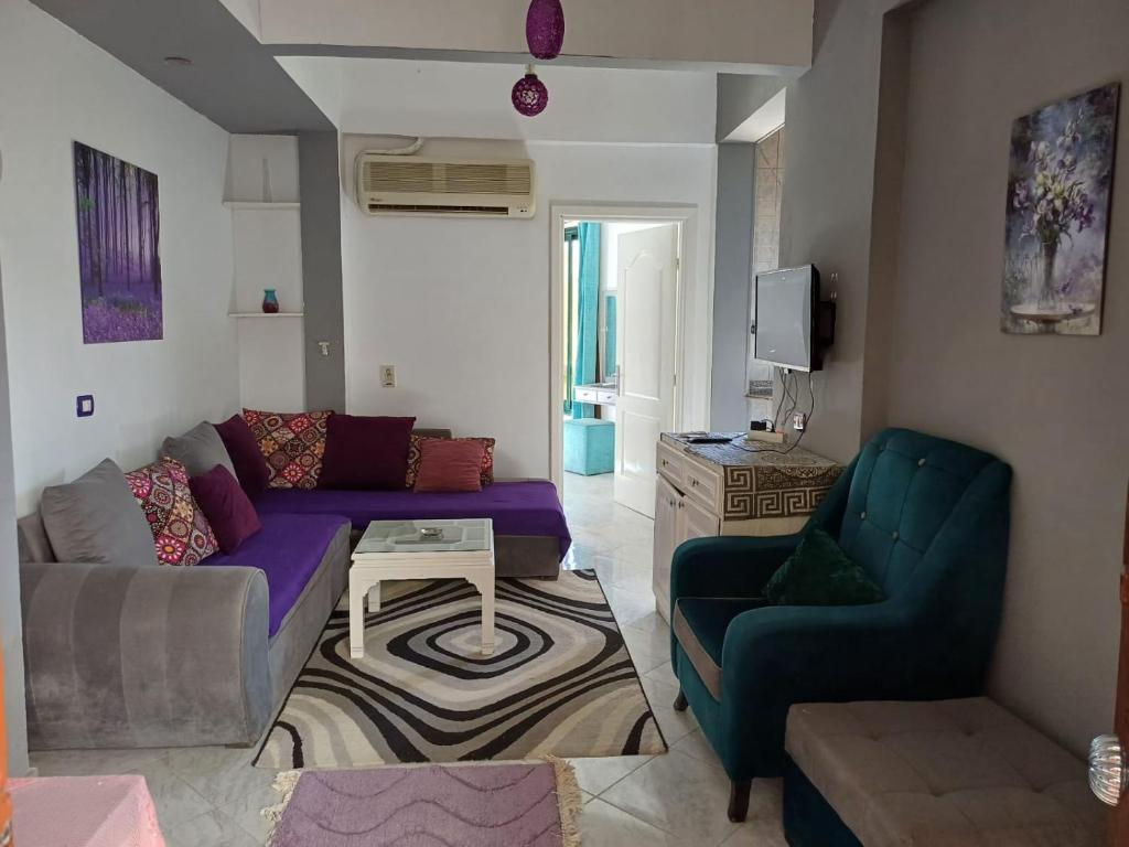- un salon avec un canapé violet et deux chaises dans l'établissement Holiday Apartment in Sunshine - Naama Bay, à Charm el-Cheikh