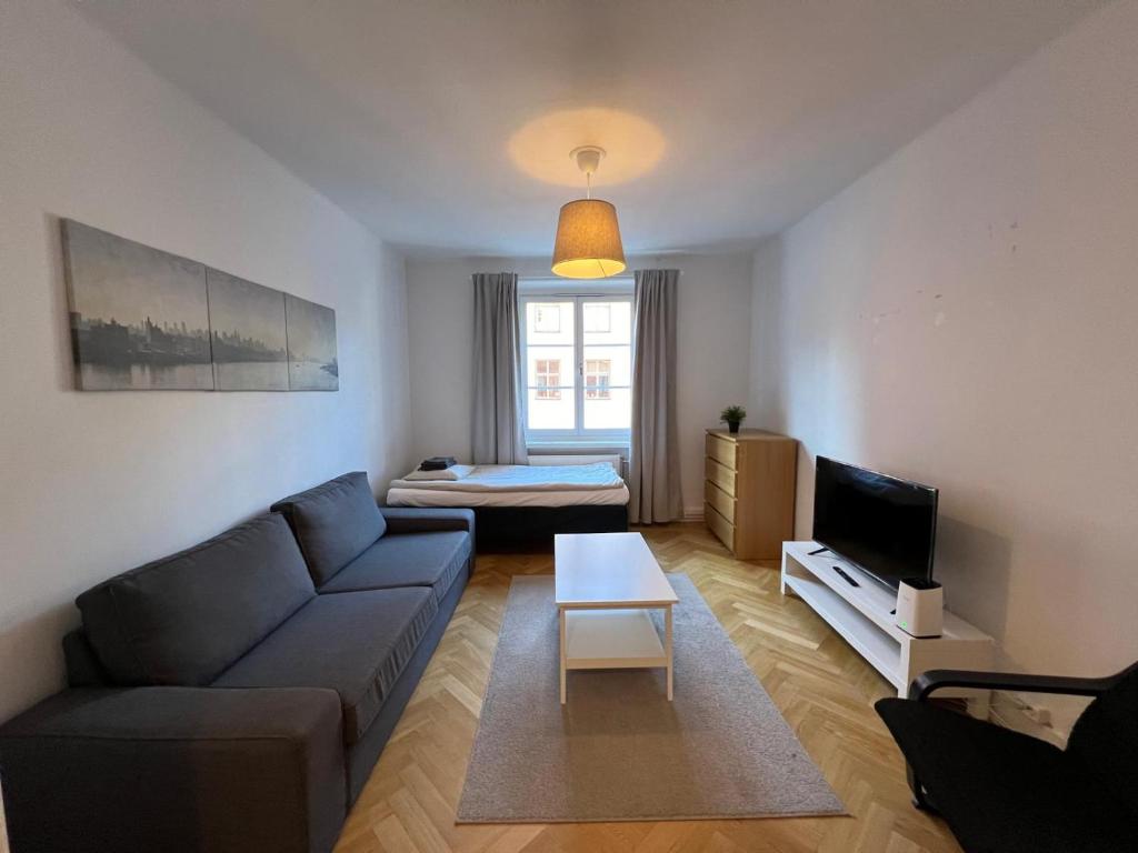 ein Wohnzimmer mit Sofa und Fernseher in der Unterkunft Home Inn RSG19 in Stockholm