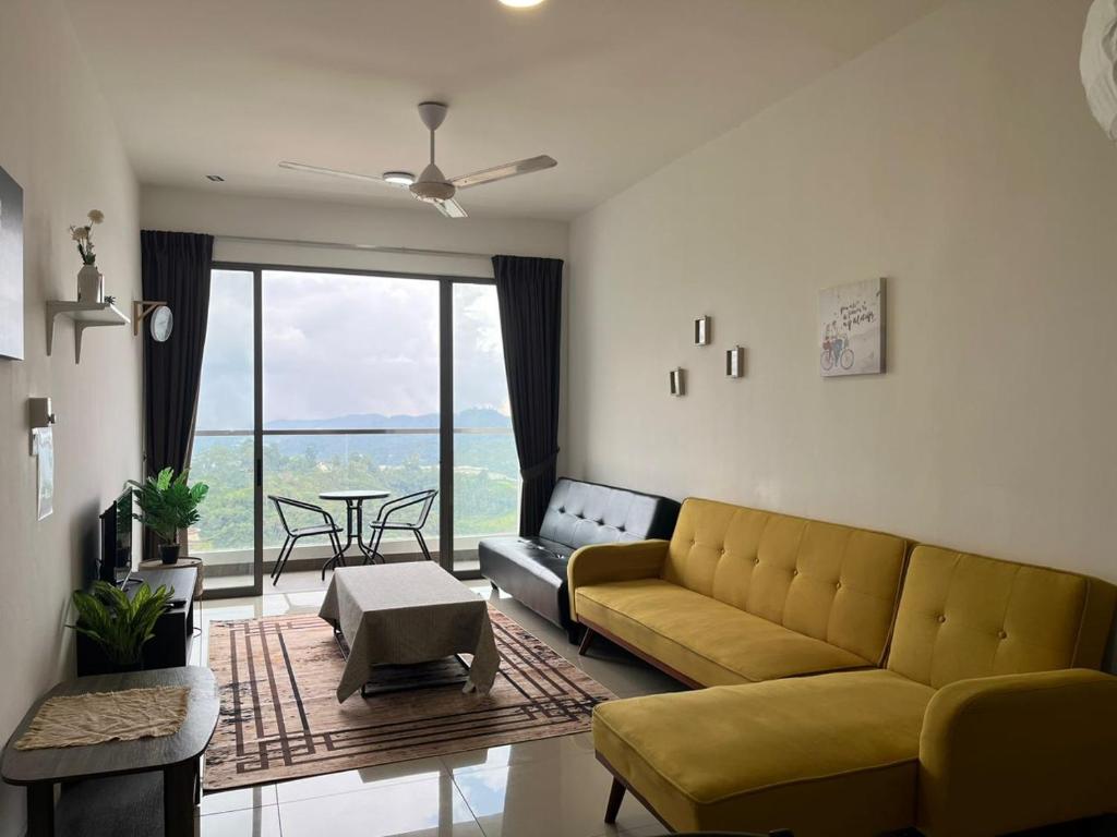 a living room with a yellow couch and a table at Ammara homestay @ Palas Horizon kea Farm in Brinchang