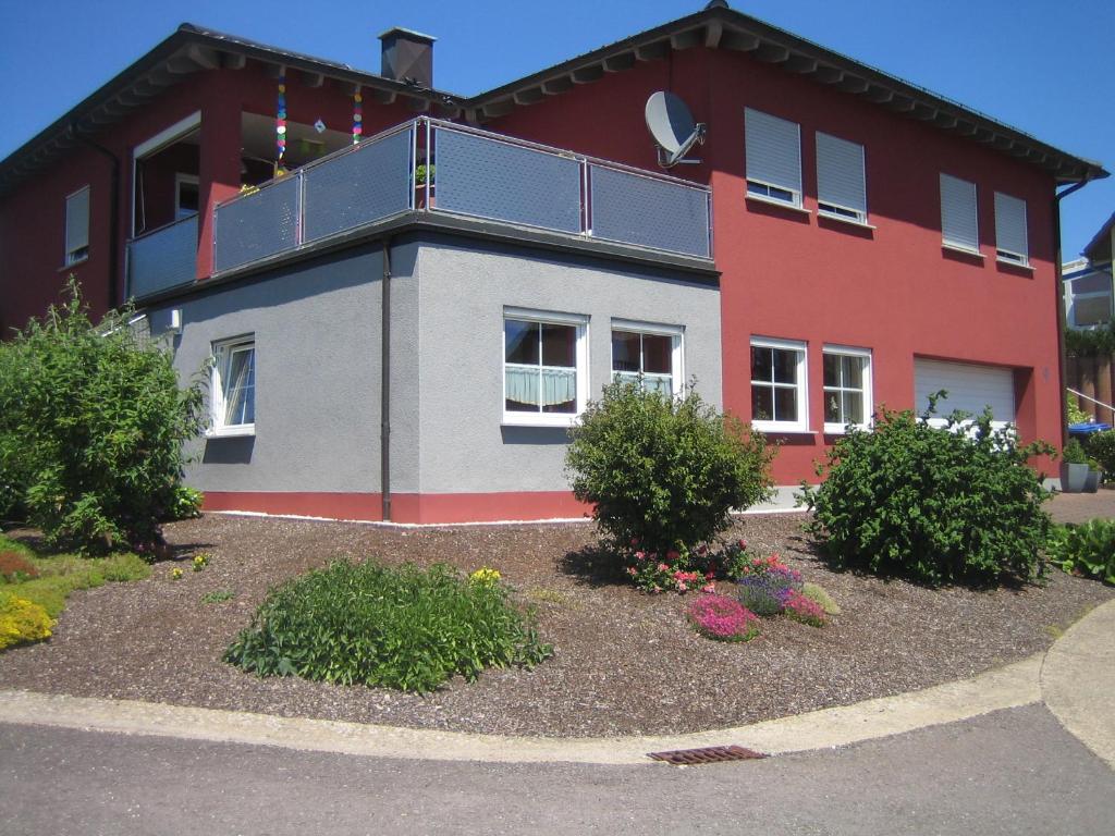 a red building with a balcony on top of it at Benkelberg in Sitzerath