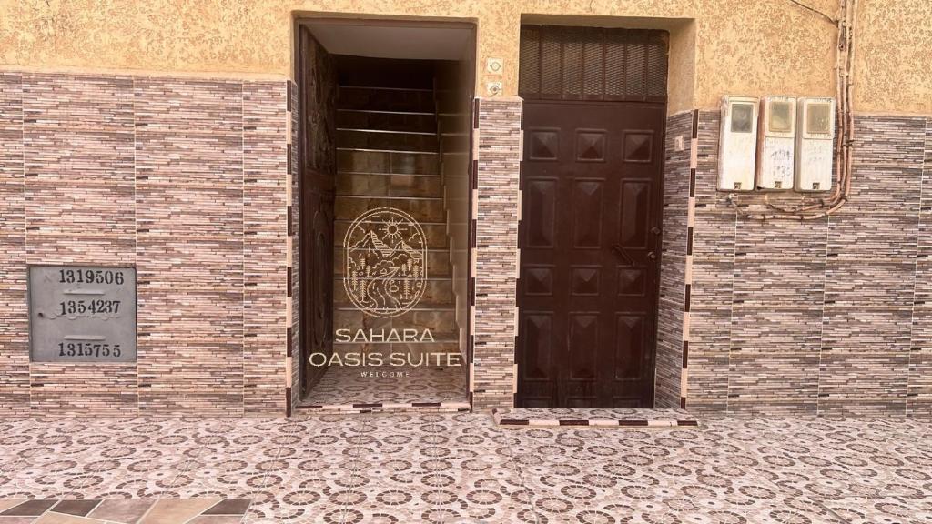 a brick building with a door with a sign on it at Appartements Meublés servitio 1 in Laayoune