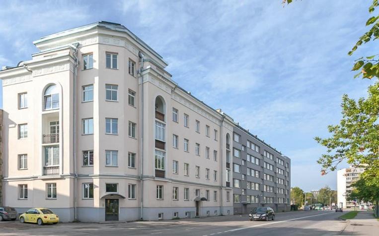 ein großes weißes Gebäude mit davor geparkt in der Unterkunft Juhkentali 32 Apartment in Tallinn
