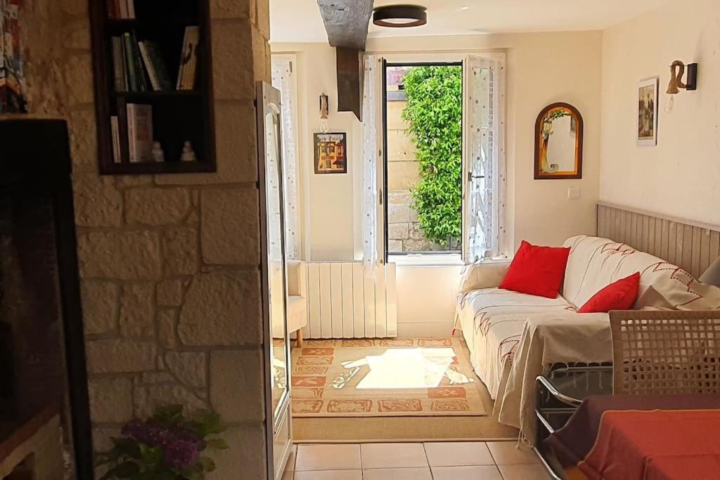 un salon avec un canapé et une fenêtre dans l'établissement Maison au centre de Honfleur, à Honfleur