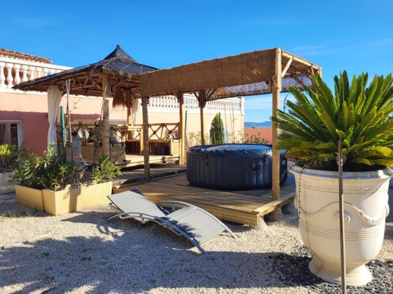 une terrasse en bois avec des chaises et un kiosque dans l'établissement Zen et nature, à Beaucaire