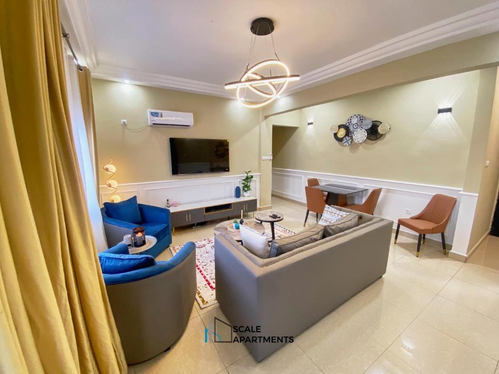 a living room with a couch and a tv at Scale Apartments in Douala