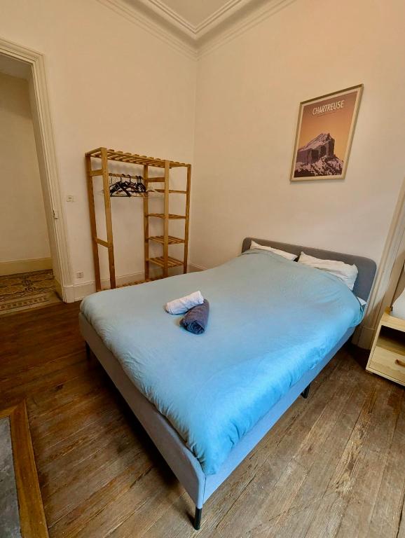 - une chambre avec un lit avec des draps bleus et une échelle dans l'établissement 3 Chambres - Hyper Centre - Calme & Tout Equipé avec Wifi, à Grenoble