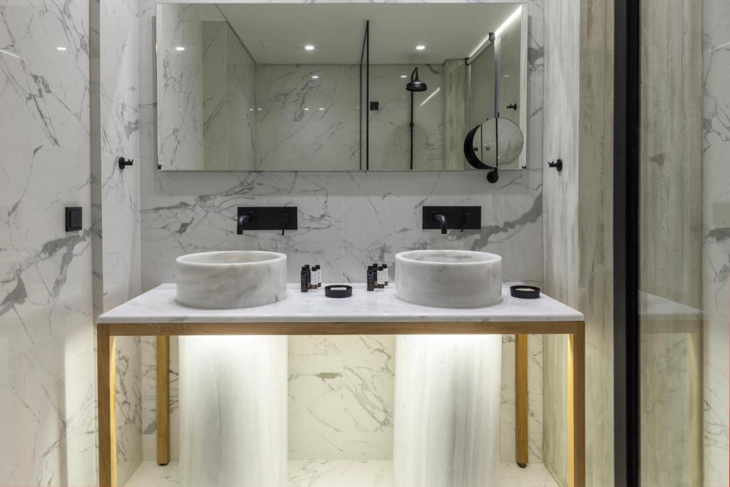 
a bathroom with two sinks and two mirrors at Coco-Mat Hotel Athens in Athens
