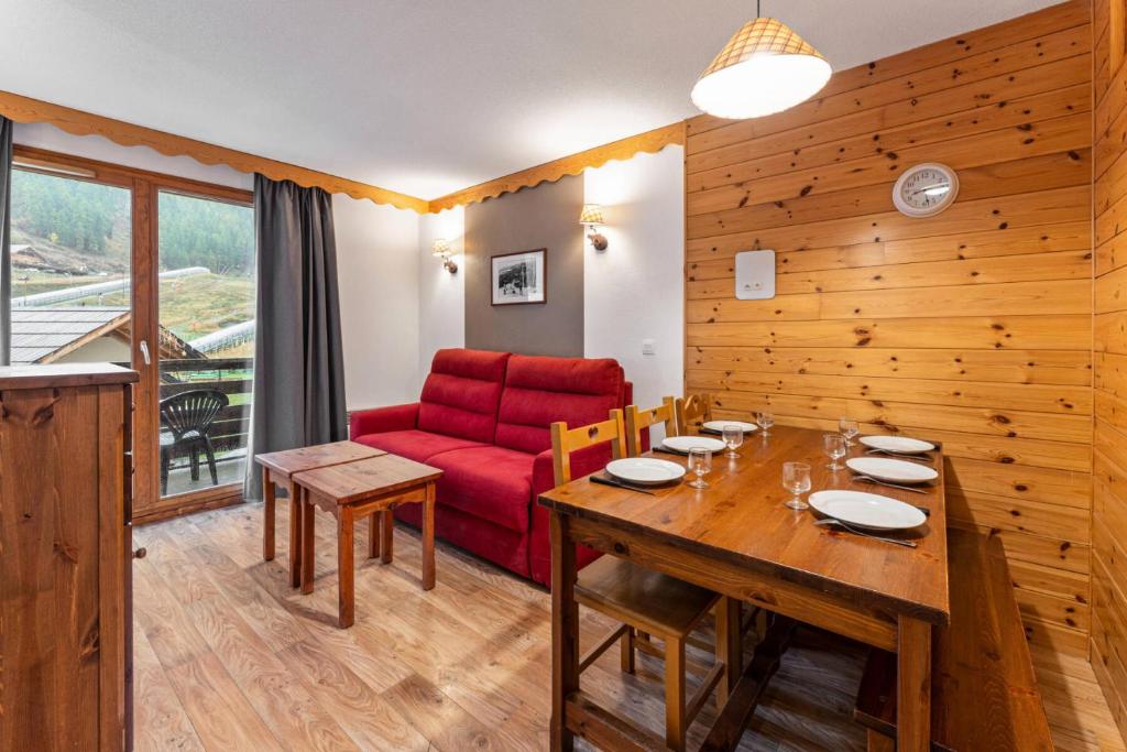 - une salle à manger avec un canapé rouge et une table dans l'établissement Résidence Les Hauts De Preclaux - Appartement au coeur des Orres 1800 MAE-0741, aux Orres