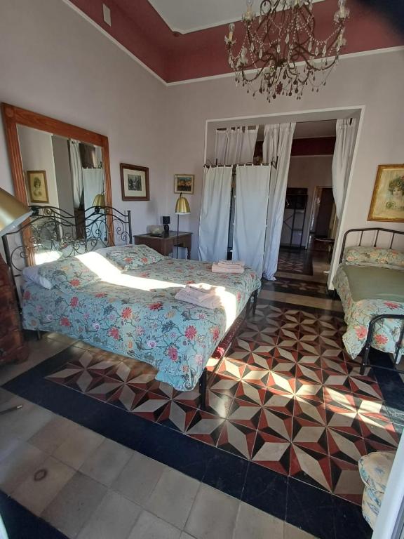 sypialnia z 2 łóżkami i żyrandolem w obiekcie Romantic House spettacolare vista mare unica nel suo genere w mieście Alghero