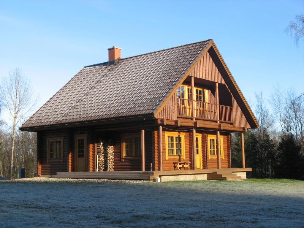 una gran casa de madera con techo de gambrel en Väike-Pärna Holiday Home, en Otepää