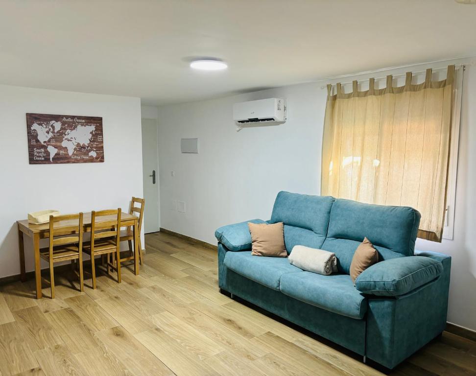 a living room with a blue couch and a table at Libertad B in Santiponce