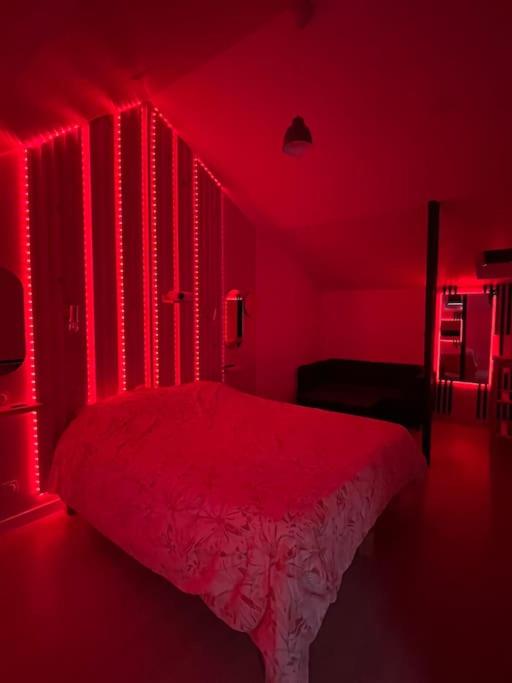 - une chambre rouge avec un lit dans une pièce dans l'établissement Love room jacuzzi proche centre ville, à Amiens
