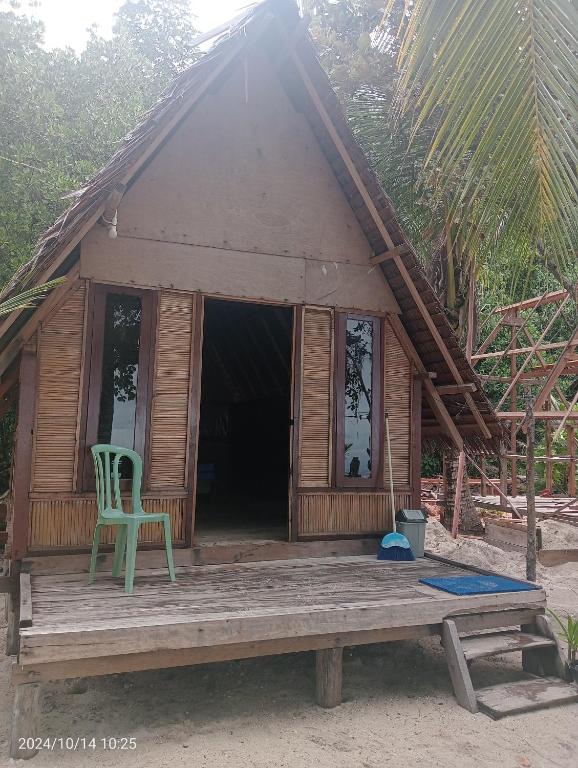 a house with a green chair on a wooden porch at Or Mandira Homestay in Fam