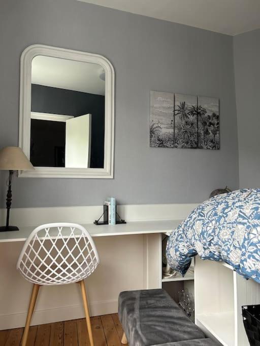 - une chambre avec un miroir, un lit et une chaise dans l'établissement Les Planches de Céline, beau T2 à Deauville, à Deauville
