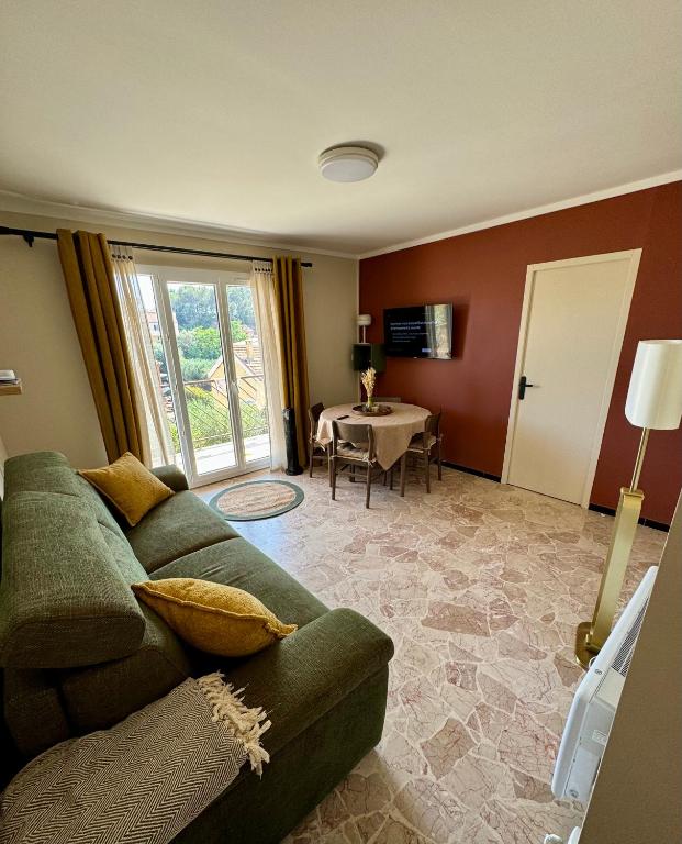 un salon avec un canapé vert et une table dans l'établissement T2 coloré proche mer terrasse parking, à Six-Fours-les-Plages