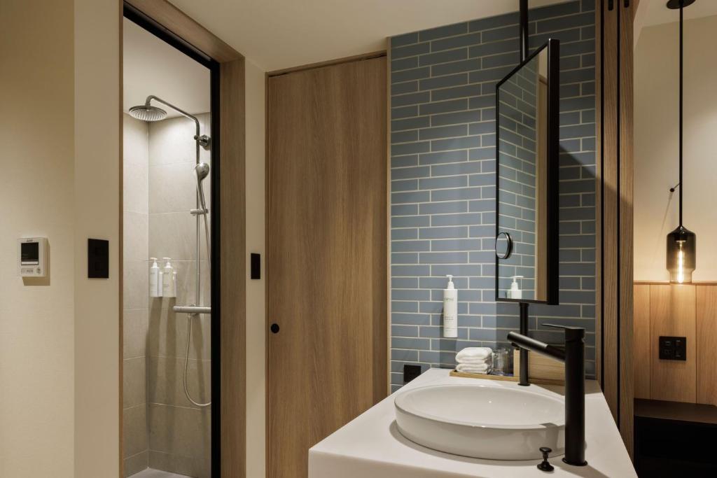 垂水市にあるFairfield by Marriott Kagoshima Sakurajimaのバスルーム(洗面台、ガラス張りのシャワー付)