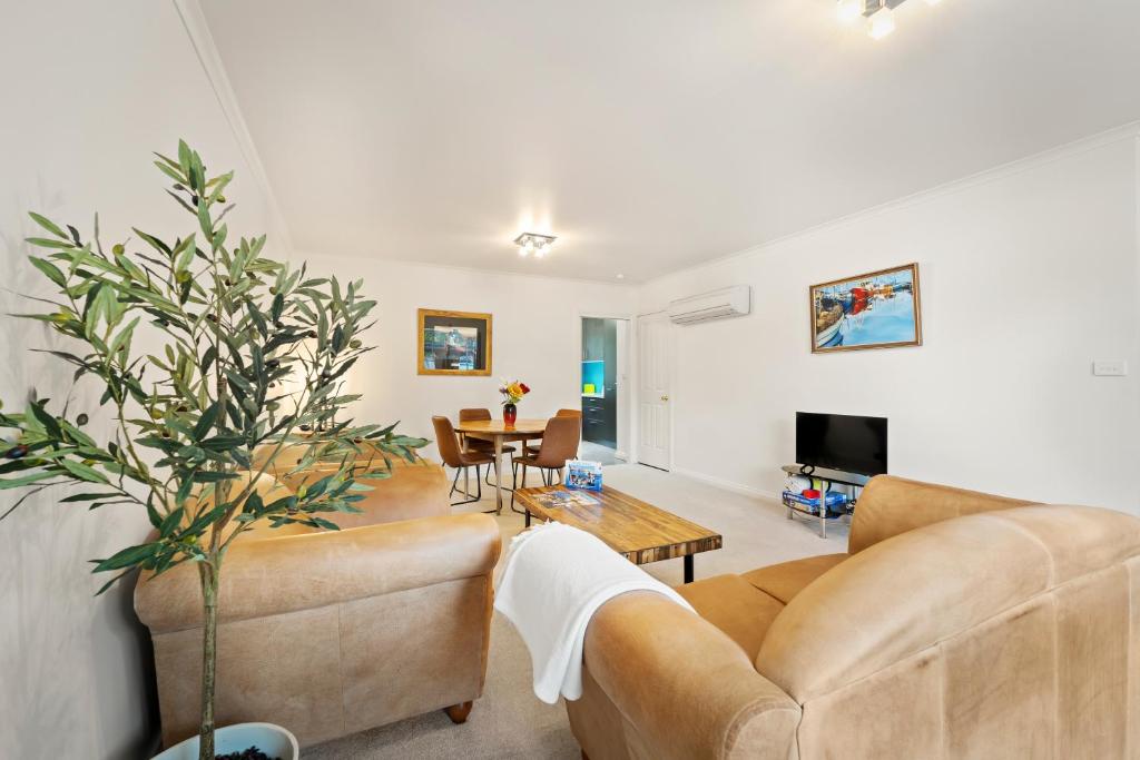 una sala de estar con un sofá y una mesa en Hobart City Townhouse, en Hobart