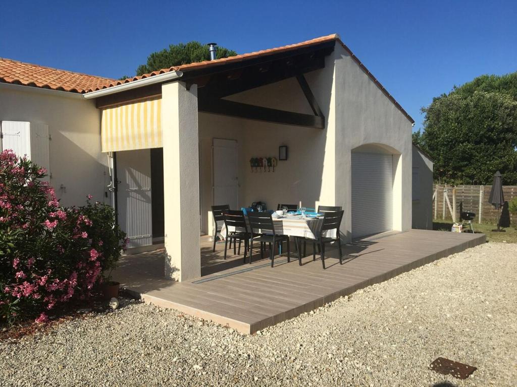 un patio avec une table et des chaises sur une terrasse dans l'établissement Maison moderne 200m plage, 4 chambres, jardin privé, Wifi, vélos - Saint-Pierre-d'Oléron - FR-1-778-35, à Saint-Pierre-dʼOléron