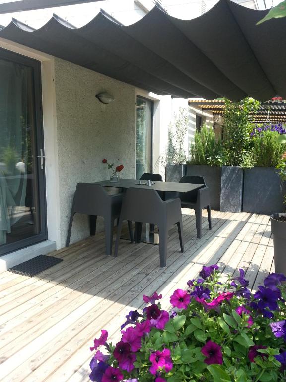 a patio with a table and chairs and flowers at Casa al Lido in Locarno