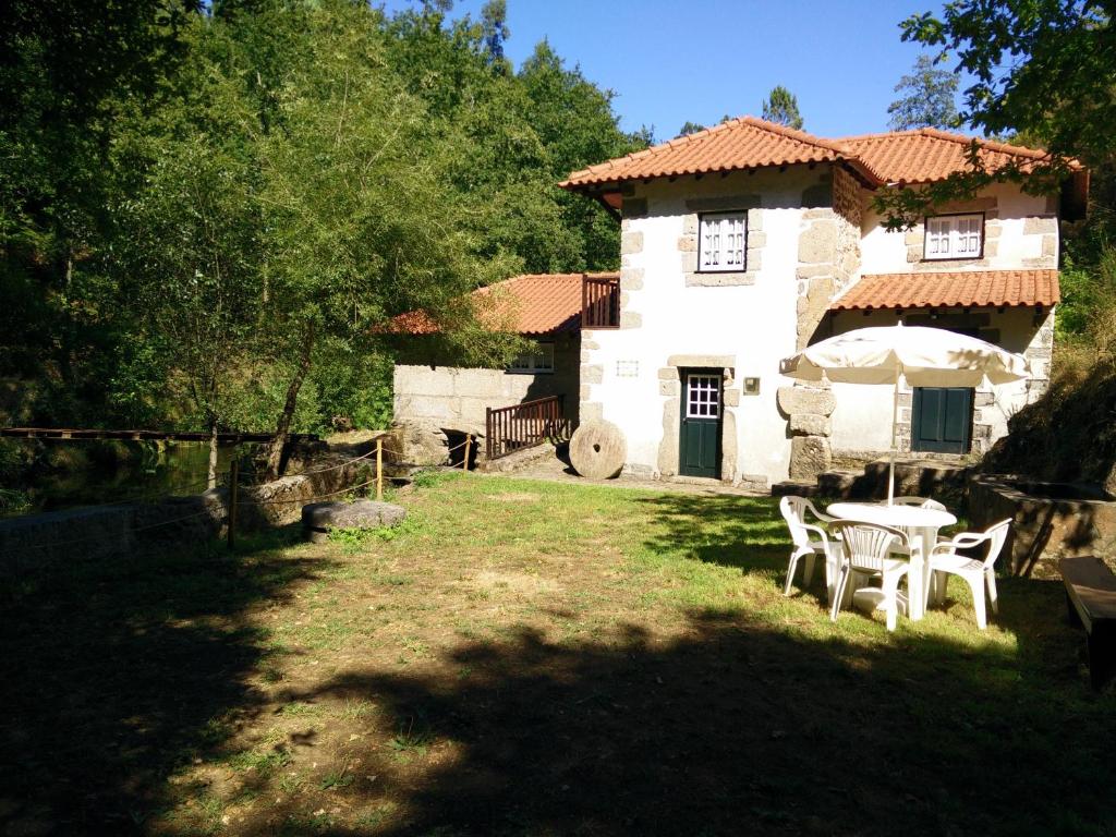 una casa con mesa y sillas en el patio en Moinho da Cruz, en Ponte de Lima