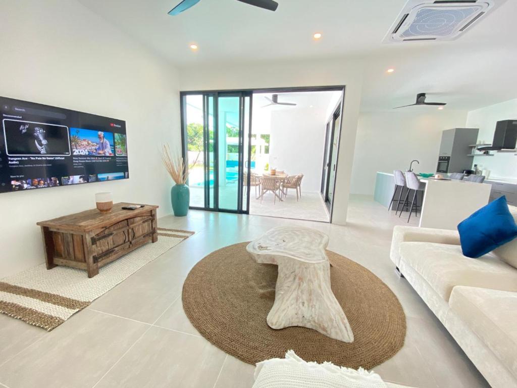 Una sala de estar con un sofá blanco y una mesa. en MANEE Jasmine Pool Villa, Bangrak, Bo Phut, Fisherman's Village, en Bangrak Beach