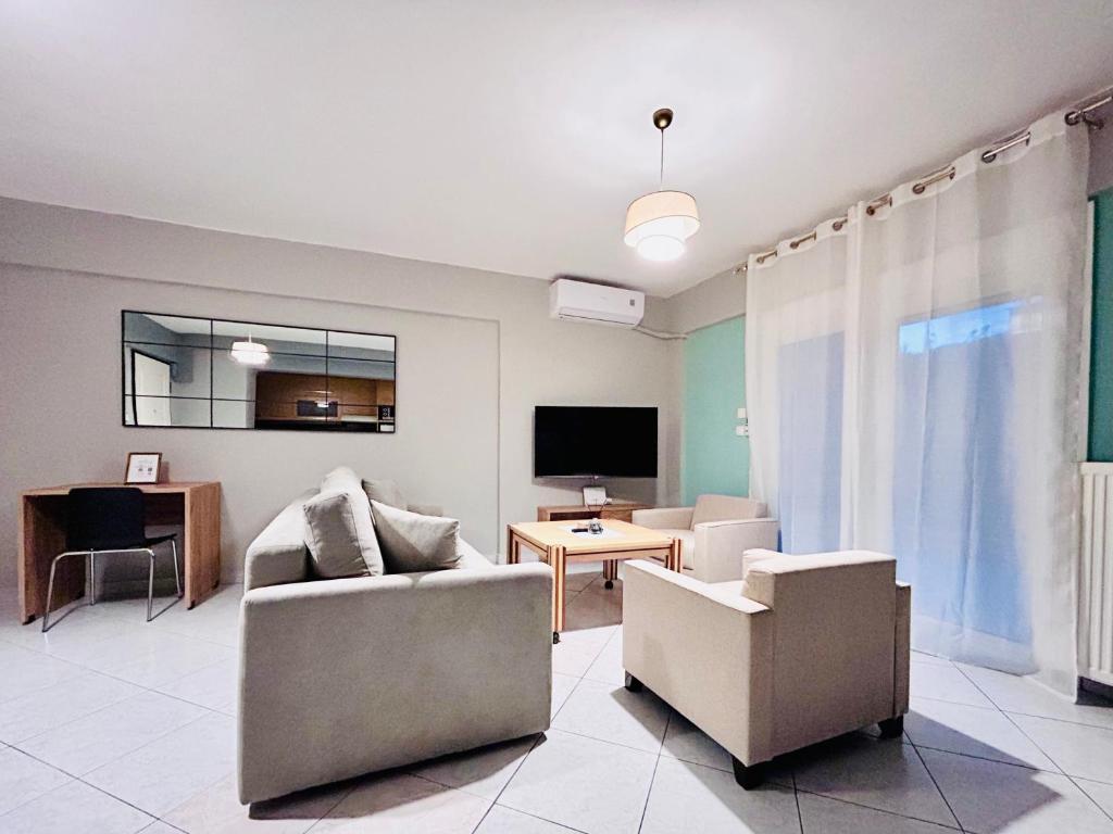 a living room with two chairs and a tv at ITHACA Άνετο διαμέρισμα 3ου με θέα in Thessaloniki