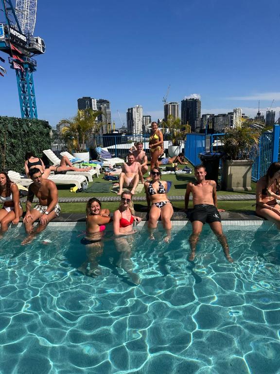 a group of people sitting in a swimming pool at City Backpackers HQ in Brisbane