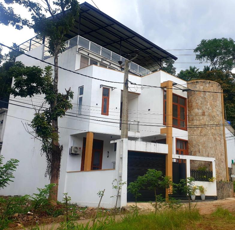 a white house with orange doors and aphalt at GAMPOLA Hazelton Square in Gampola