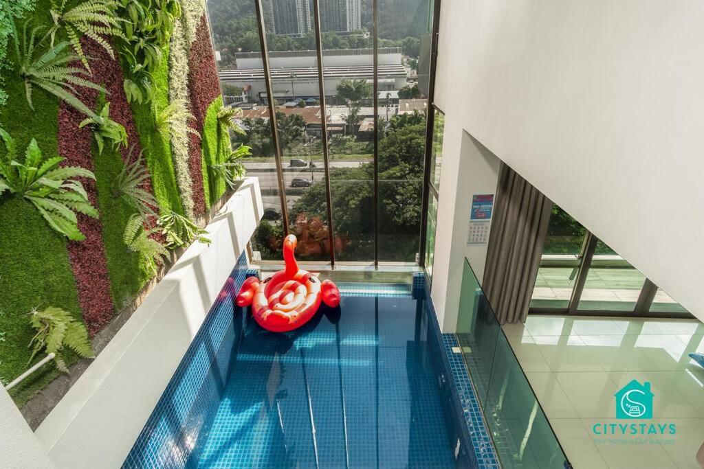 a swimming pool in a building with a red raft at D'Moon Escapes Ampang KL 4BR in Kampong Ulu Kelang