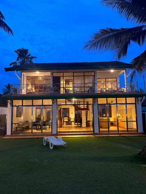 a large house with a lot of windows at Villa Leela Bentota in Induruwa