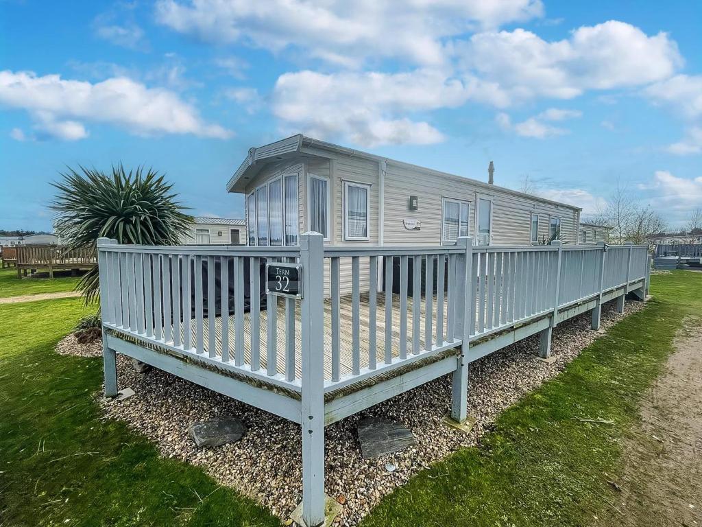 a mobile home with a porch on the grass at 6 Berth Caravan With Wifi At Wells-Next-The-Sea In Norfolk Ref 72032T in Wells next the Sea