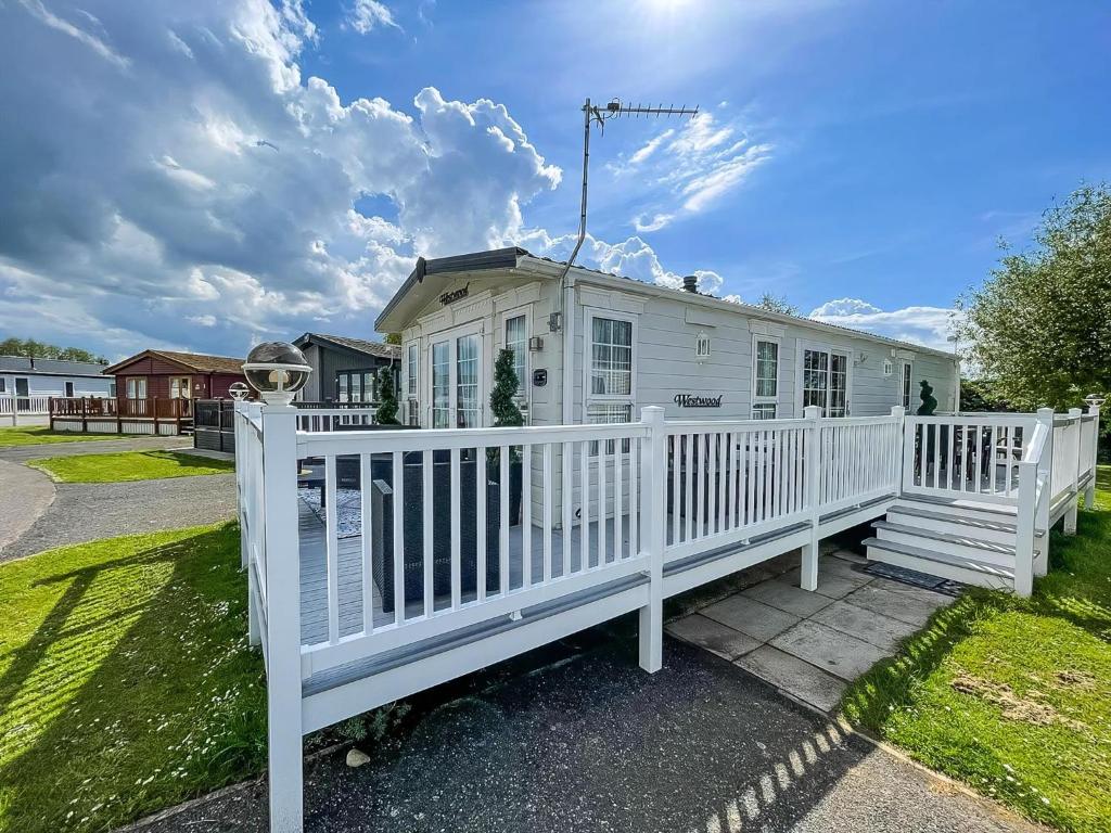 a white house with a white fence at Beautiful Caravan At Manor Park In Hunstanton Beach, Norfolk Ref 23026H in Hunstanton