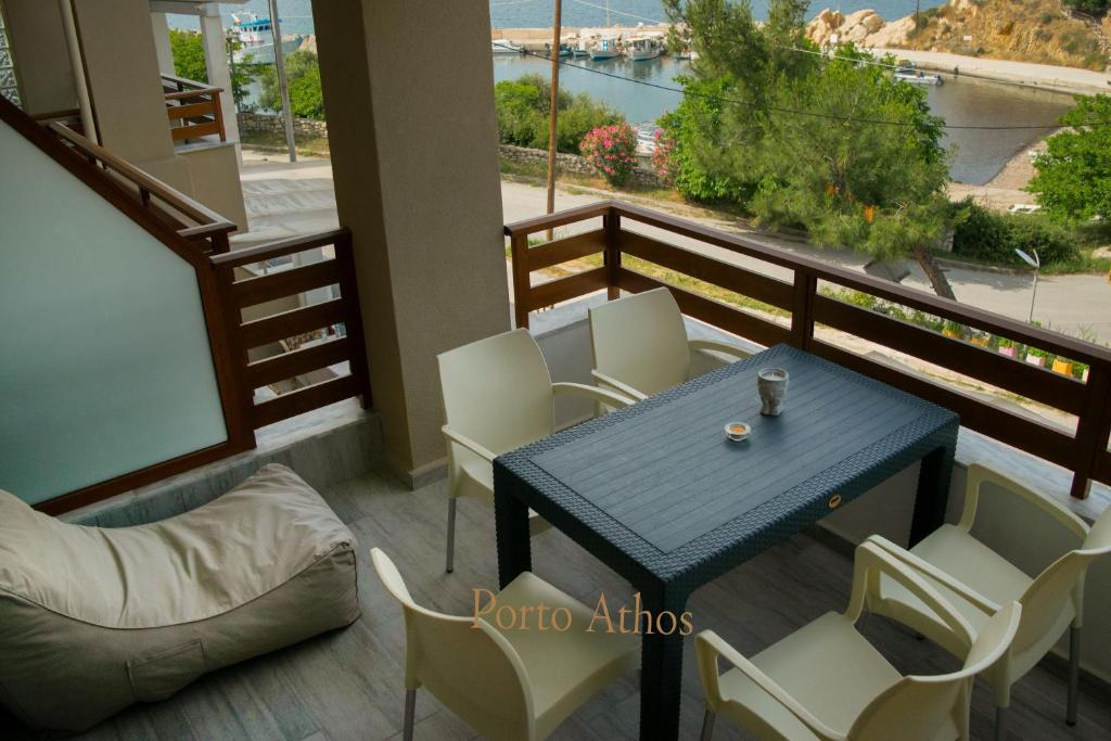 a balcony with a blue table and white chairs at Porto Athos apartments 1345 in Nea Roda